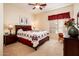 This well-lit main bedroom includes a ceiling fan, a dresser, and charming decor and wall art at 13434 W El Sueno Ct, Sun City West, AZ 85375