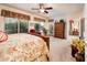 An airy main bedroom is decorated with a floral bedspread and looks out onto a private patio at 13434 W El Sueno Ct, Sun City West, AZ 85375