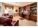 An elegant office features built-in bookshelves, red leather chairs, and stylish wallpaper at 13434 W El Sueno Ct, Sun City West, AZ 85375