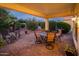 Cozy covered patio with desert landscaping and an outdoor dining set at 13434 W El Sueno Ct, Sun City West, AZ 85375