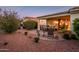 Cozy covered patio with dining and seating area, surrounded by desert landscaping at 13434 W El Sueno Ct, Sun City West, AZ 85375