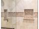 Shower with custom tile work, built-in shelves, and glass door at 13434 W El Sueno Ct, Sun City West, AZ 85375