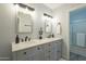 Bathroom with dual sinks, gray cabinets, and modern lighting fixtures at 15801 N 29Th St # 11, Phoenix, AZ 85032