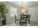 Dining area featuring a glass table, four chairs, chandelier, and a decorative potted plant at 15801 N 29Th St # 11, Phoenix, AZ 85032