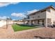 Expansive backyard with artificial turf, pavers, and a covered patio, ideal for outdoor living and entertaining at 16918 W Statler St, Surprise, AZ 85388
