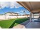 Spacious backyard with green artificial turf, pavers, a gazebo, and a covered patio for relaxation at 16918 W Statler St, Surprise, AZ 85388