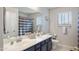 Well-lit bathroom featuring a double sink vanity, neutral walls, and a shower/tub combination at 16918 W Statler St, Surprise, AZ 85388
