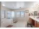 Spacious bathroom featuring double vanity, tub, shower, and a zebra print stool at 16918 W Statler St, Surprise, AZ 85388