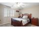 Bedroom with a wooden frame bed, plush carpet, and a ceiling fan at 16918 W Statler St, Surprise, AZ 85388