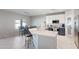 Bright kitchen boasts a large island with seating, stylish white cabinetry, and modern appliances at 16918 W Statler St, Surprise, AZ 85388