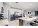 An open kitchen with a large island with counter seating, stainless steel appliances, and white countertops at 16918 W Statler St, Surprise, AZ 85388
