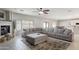 A large living room with a fireplace, tile floors, and a large sectional sofa at 16918 W Statler St, Surprise, AZ 85388