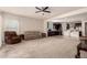 Inviting living room featuring neutral carpet, a ceiling fan, and direct access to the adjacent kitchen at 17462 W Straight Arrow Ln, Surprise, AZ 85387