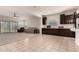 Open-concept living room with tile flooring, a ceiling fan, and seamless transition to the kitchen at 17462 W Straight Arrow Ln, Surprise, AZ 85387