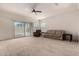Bright living room with sliding glass doors, neutral carpet, and comfortable seating arrangement at 17462 W Straight Arrow Ln, Surprise, AZ 85387