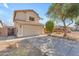Two-story home featuring a tile roof, attached garage, and mature landscaping in the front yard at 17473 N 167Th Dr, Surprise, AZ 85374