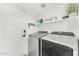Functional laundry room with modern appliances, built-in shelving, offering convenient and efficient space at 17473 N 167Th Dr, Surprise, AZ 85374
