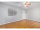 A bright bedroom with wood-look floors, ceiling fan, and a window with blinds at 18202 N Cave Creek Rd # 134, Phoenix, AZ 85032