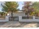 Charming single-story home with a decorative fence and mature trees in the front yard at 1933 W Ocotillo Rd, Phoenix, AZ 85015