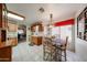 Bright kitchen/dining area featuring tile flooring, warm cabinets, decorative lighting and an open floorplan at 19427 N 84Th Ave, Peoria, AZ 85382