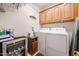 Functional laundry room with washer, dryer, wine cooler and cabinet storage at 19427 N 84Th Ave, Peoria, AZ 85382