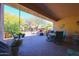 Covered patio with brick pavers, a seating area with chairs, a table, and views of the community at 19427 N 84Th Ave, Peoria, AZ 85382