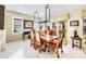 Elegant dining room with a rustic wood table, red upholstered chairs, and a modern chandelier at 20044 N London Bridge Dr, Surprise, AZ 85387