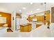 Bright kitchen featuring an island, tile flooring, wooden cabinets, white appliances, and spacious countertops at 20044 N London Bridge Dr, Surprise, AZ 85387