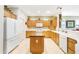 Bright kitchen featuring an island, tile flooring, wooden cabinets, white appliances, and spacious countertops at 20044 N London Bridge Dr, Surprise, AZ 85387