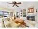 Spacious living room with a cozy fireplace, comfortable seating, and views of the landscaped yard at 20044 N London Bridge Dr, Surprise, AZ 85387
