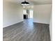 Spacious living room with grey wood floors, bright light fixture and open access to the kitchen at 2018 W Western Dr, Chandler, AZ 85224