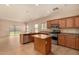 Open concept kitchen featuring stainless steel appliances, wood cabinets, and a center island with countertop at 21333 N Denton Dr, Maricopa, AZ 85138