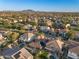 Aerial view of neighborhood showcasing various houses with backyard pools and mountain views in the distance at 2134 E Honeysuckle Pl, Chandler, AZ 85286