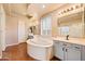 Bright bathroom featuring a large soaking tub, double sinks, and neutral color palette at 2134 E Honeysuckle Pl, Chandler, AZ 85286