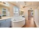 Bright bathroom featuring a large soaking tub, double sinks, and arched doorway at 2134 E Honeysuckle Pl, Chandler, AZ 85286