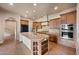 Open kitchen with an island, wood cabinets, tile floors, and stainless steel appliances at 2134 E Honeysuckle Pl, Chandler, AZ 85286