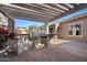Outdoor kitchen under a pergola featuring built in bbq, sink, mini fridge and brick pavers at 2134 E Honeysuckle Pl, Chandler, AZ 85286