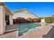 Backyard pool with lush landscaping, rock features, and an outdoor kitchen under a pergola at 2134 E Honeysuckle Pl, Chandler, AZ 85286