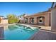 Backyard pool with lush landscaping, rock features, and a covered patio at 2134 E Honeysuckle Pl, Chandler, AZ 85286