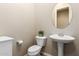 Half bathroom featuring a pedestal sink, toilet, and decorative mirror at 2453 E Ebony Dr, Chandler, AZ 85286
