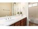 Bathroom with cherry wood cabinets, white countertop and sink, next to a shower and toilet at 2453 E Ebony Dr, Chandler, AZ 85286