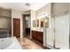 Large bathroom showcasing separate vanities, walk-in shower, soaking tub, and laundry area at 2453 E Ebony Dr, Chandler, AZ 85286
