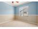 Bedroom featuring blue and tan walls, carpet flooring, and a bright window at 2453 E Ebony Dr, Chandler, AZ 85286