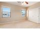 Carpeted bedroom with neutral walls, a ceiling fan, two bright windows, and a closet at 2453 E Ebony Dr, Chandler, AZ 85286