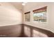 Bedroom featuring dark wood flooring, neutral paint, and windows showcasing a pool at 2453 E Ebony Dr, Chandler, AZ 85286
