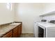 Laundry room featuring a utility sink, brown cabinets, shelving, and front loading washer and dryer at 2453 E Ebony Dr, Chandler, AZ 85286