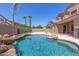 Backyard oasis featuring a rock waterfall pool, mature palm trees, and an outdoor fire pit at 2453 E Ebony Dr, Chandler, AZ 85286