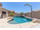 Sparkling pool featuring an outdoor fire pit, rock waterfall, and mature palm trees at 2453 E Ebony Dr, Chandler, AZ 85286