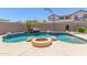 Backyard oasis featuring a rock waterfall pool, mature palm trees, and an outdoor fire pit at 2453 E Ebony Dr, Chandler, AZ 85286