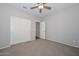 Bedroom featuring a ceiling fan, neutral carpet, and closet with double doors at 25651 N 161St Ave, Surprise, AZ 85387